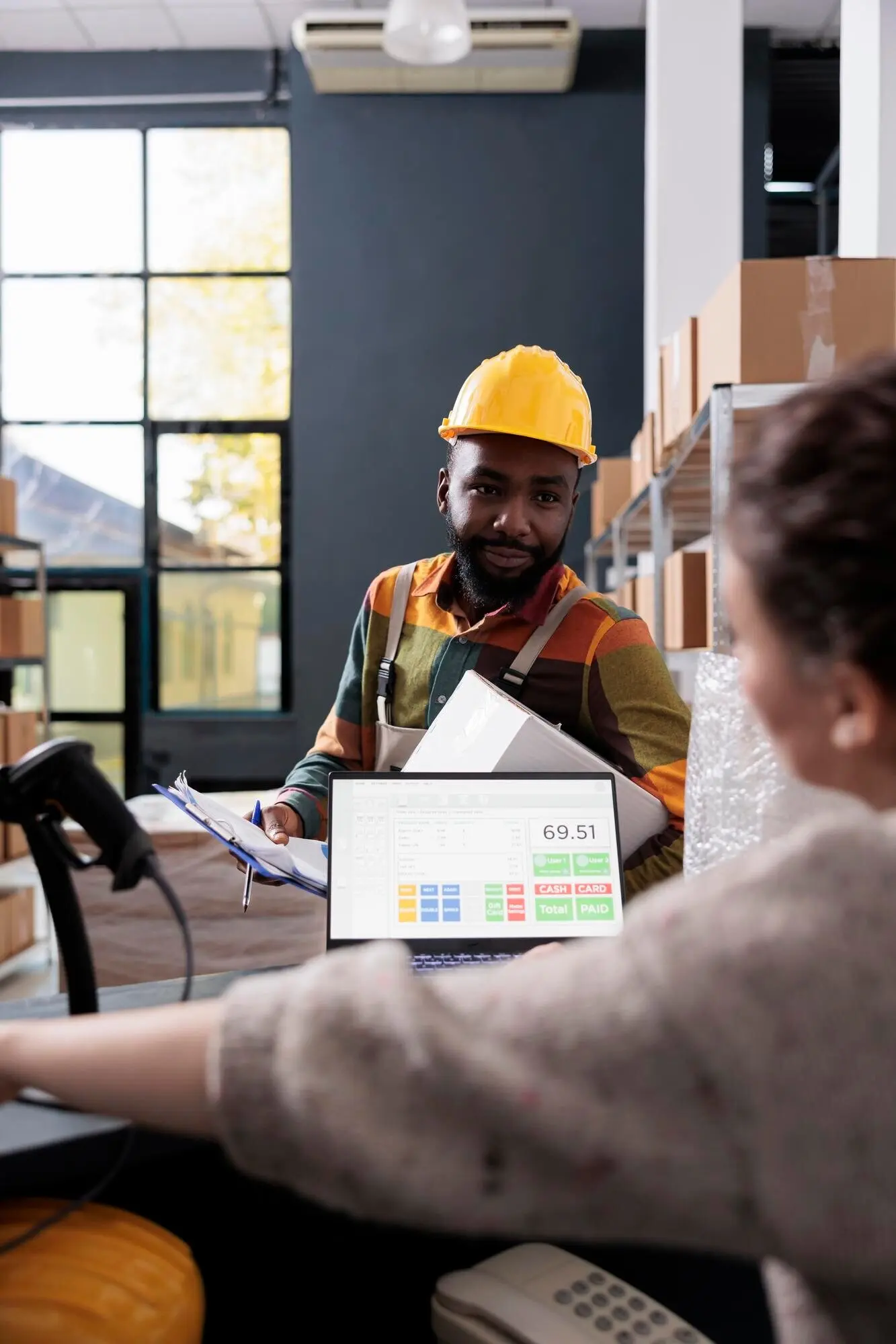 Афроамериканский сотрудник обсуждает чек-лист товаров.